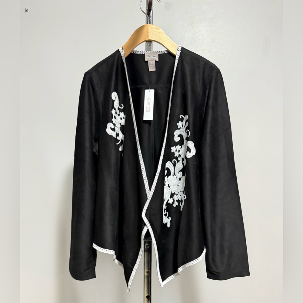 Chico's ..Open black kimono-style jacket, featuring white embroidery and piping.